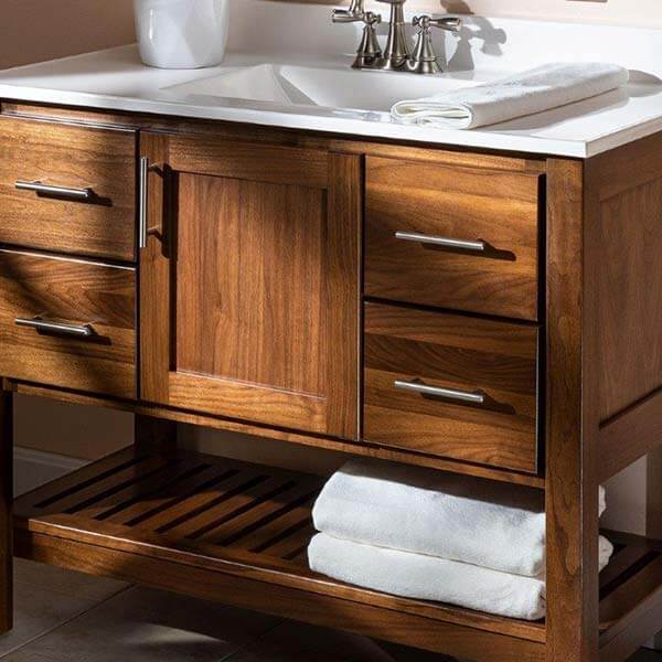 Bathroom vanity that is wooden with a rack of white towels